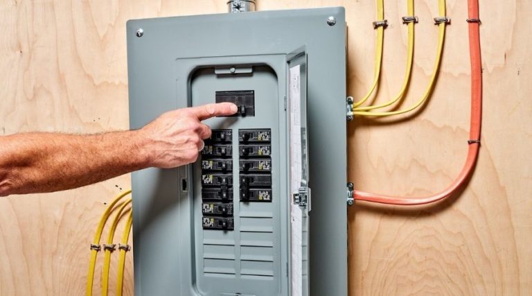 Man flipping a switch on an electrical panel
