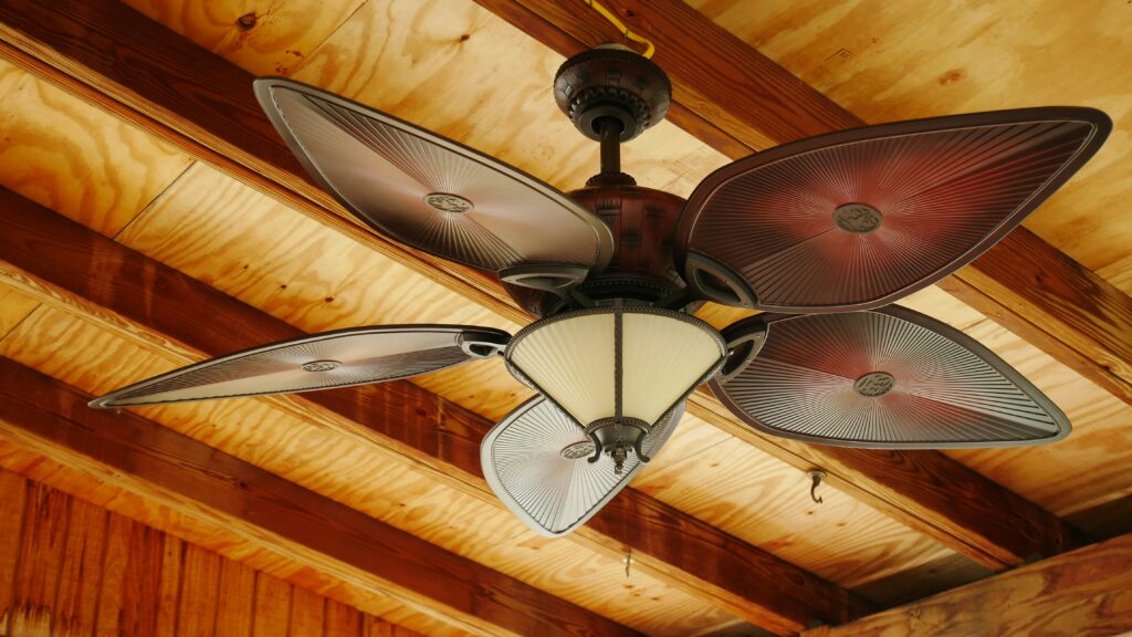 Close view of a new outdoor ceiling fan on a covered porch.