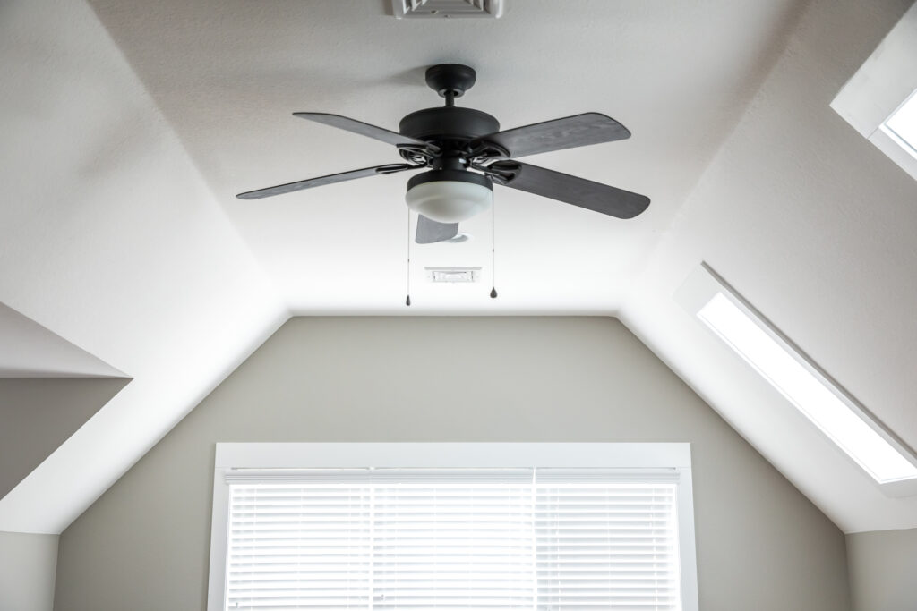 New ceiling fan installed in a bonus room with white walls.